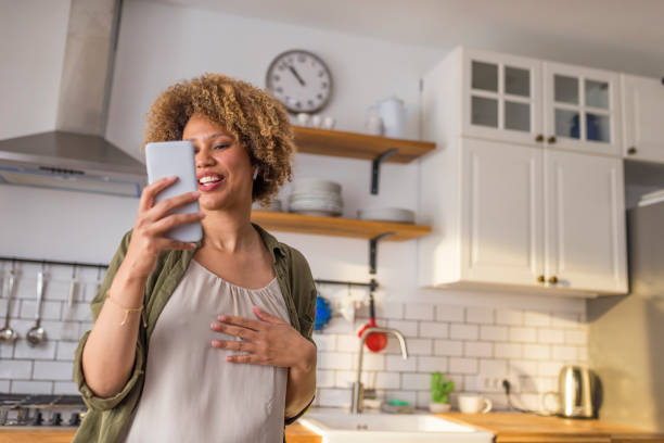 istock Young woman talking on video call in kitchen 1283860124