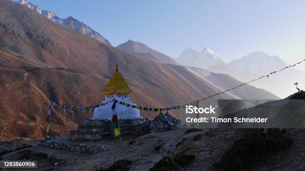 Buddhist Monument Surrounded By Mani Stones And Colorful Prayer Flags In The Bright Evening Sun In Dingboche Khumbu Nepal In The Majestic Himalayas Stock Photo - Download Image Now