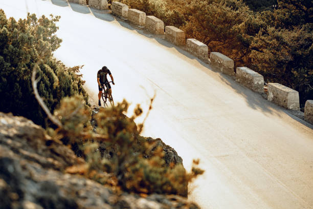 istock Professional cyclist on a mountain road at sunrise 1283861053