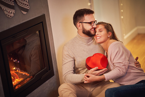 Picture showing adult couple with present over fireplace