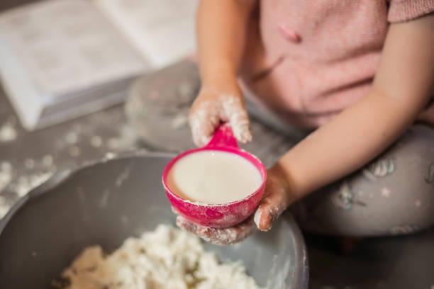 toddler making pancake batter - one baby girl only fotos imagens e fotografias de stock