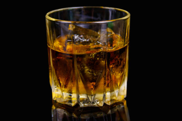 istock Glass of whiskey with ice on a black background 1283868688