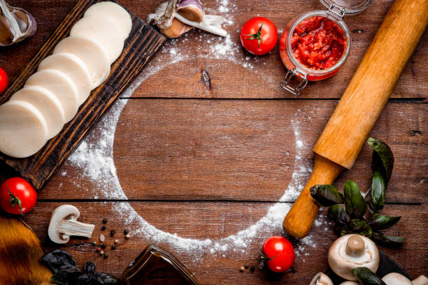 istock Pizza ingredients on wooden background with free space for text 1283868726