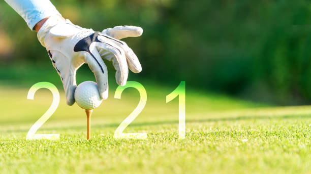 golfer frau setzen golfball für happy new year 2021 auf dem grünen golf für neue gesunde.  kopierraum. gesundes und urlaubskonzept. - condition optimal text healthy lifestyle stock-fotos und bilder