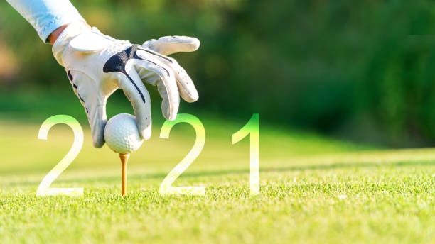 golfer woman putting golf ball for happy new year 2021 on the green golf for new healthy.  copy space. healthy and holiday concept. - golf hole ball grass imagens e fotografias de stock