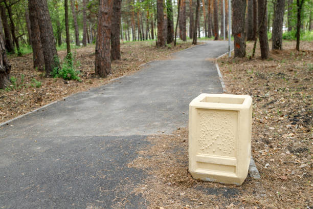 istock an asphalted path for walking in the park, a litter bin is installed on the edge 1283871403