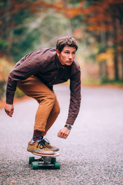 istock Young Man Rides Fast A Skateboard On The Road 1283872448