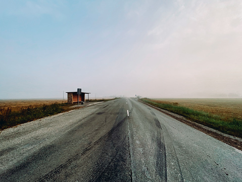 Empty road and bus stop in rural area near Barta, Latvia