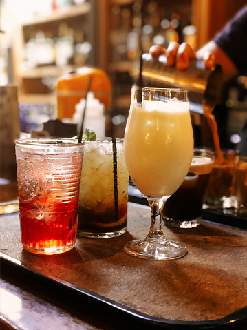 Set of assorted alcohol beverages in glasses placed on tray on counter in pub