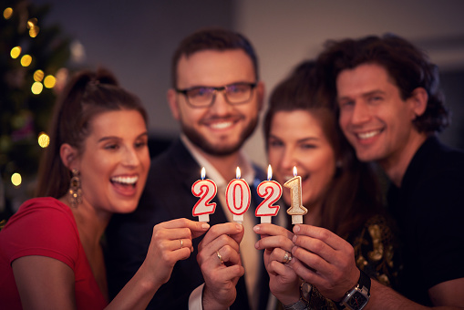 Two beautiful young couples having fun at New Year's Eve Party holding numbers 2020