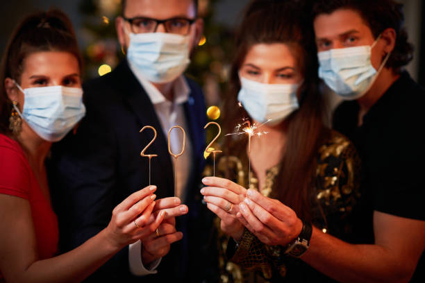 Two beautiful young couples having fun at New Year's Eve Party Two beautiful young couples having fun at New Year's Eve Party holding numbers 2020 new years eve covid stock pictures, royalty-free photos & images