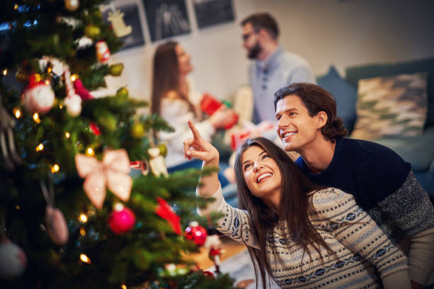 istock Adult couples having fun over Christmas tree 1283875880