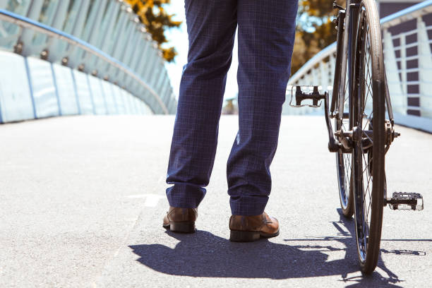 istock Friendly businessman leading his bicycle on a bridge 1283878427