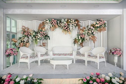 White theme of wedding stage decoration with colorful flowers and chair for guest in asian traditional married