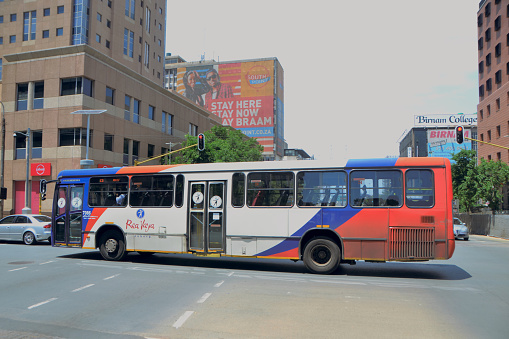 Johannesburg, South Africa - November 02, 2020: public transport bus driving through an intersection in the city midday Braamfontein