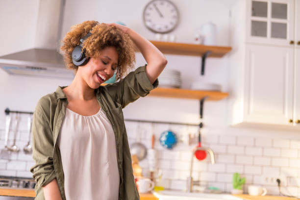 istock Young woman dancing in kitchen while listening music 1283880765