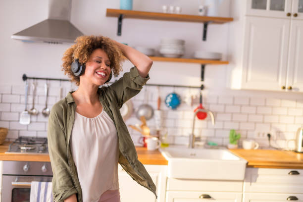 istock Young woman dancing in kitchen while listening music 1283880886