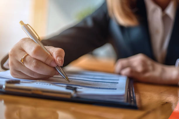 istock Closeup of Hand with pen over application form. 1283882072