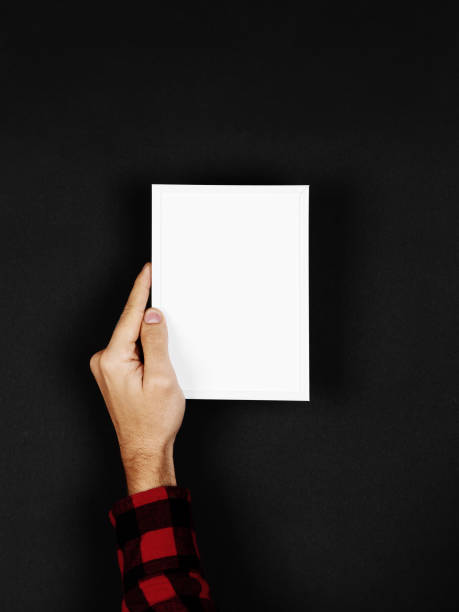 istock Photo frame in hands on a black background. Preparation for text, mockup, copy space. 1283882168
