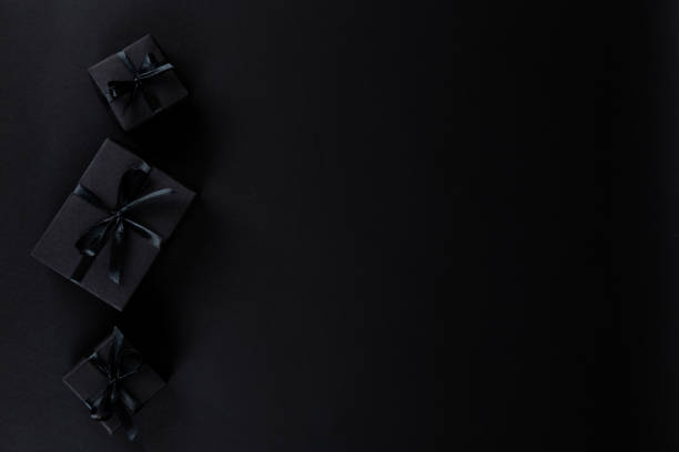 istock Black gift paper black background. Dark concept, sales. Copy space. 1283882197