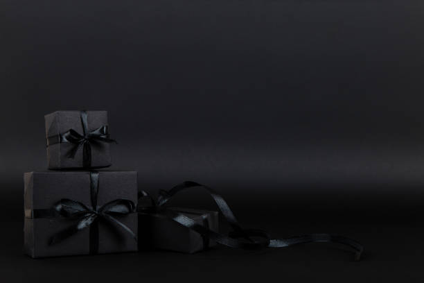 istock Black gift paper black background. Dark concept, sales. Copy space. 1283882210