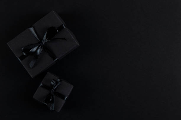istock Black gift paper black background. Dark concept, sales. Copy space. 1283882264