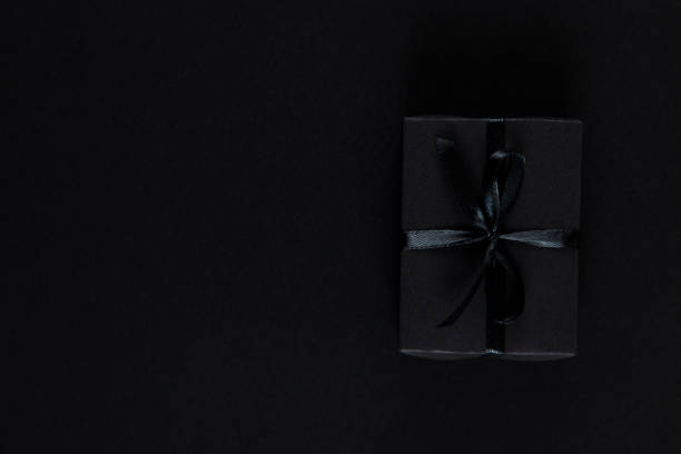 istock Black gift paper black background. Dark concept, sales. Copy space. 1283882414