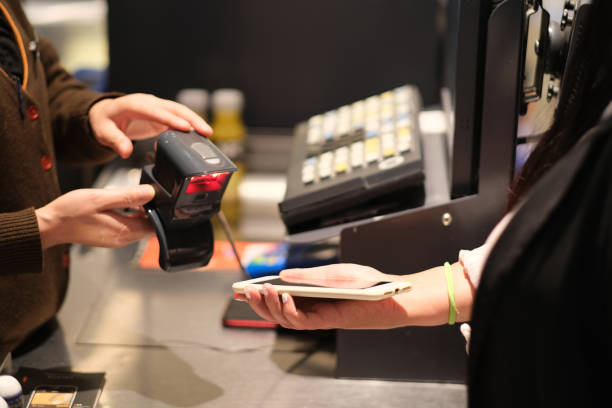 istock using phone to pay at checkout in supermarket 1283883223