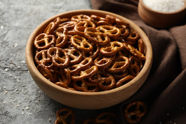 istock Napkin and bowl with cracker pretzels on gray background 1283883560