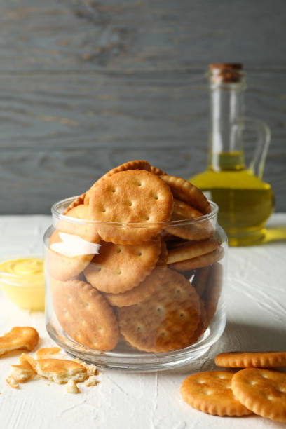istock Glass jar with crackers, sauce and oil on white table 1283883696