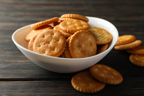 istock Bowl with tasty cracker biscuits on wooden background 1283883746