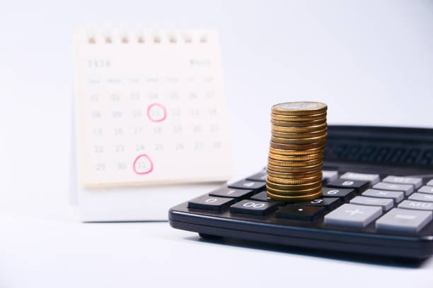 istock stack of coins and calendar on white background 1283883939