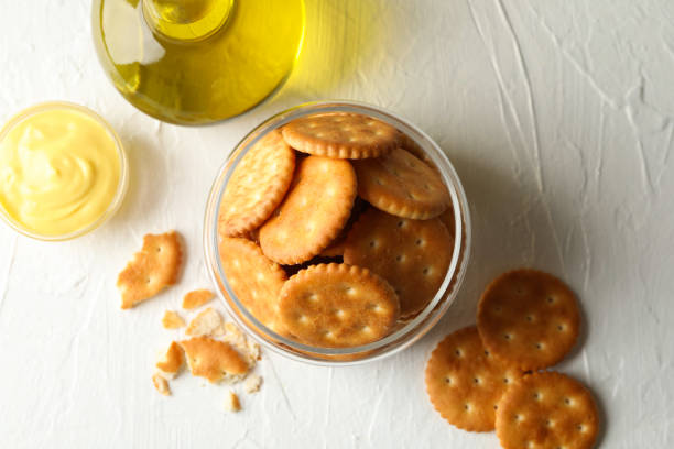istock Glass jar with crackers, sauce and oil on white table 1283884537