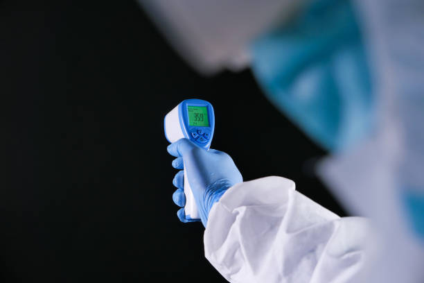 istock Hand holding infrared thermometer to measuring temperature. isolated on black 1283884683