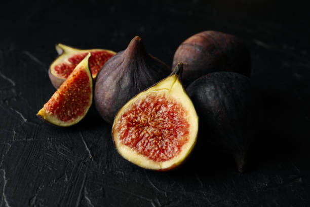 istock Fresh fig fruits and slices on black background 1283888203