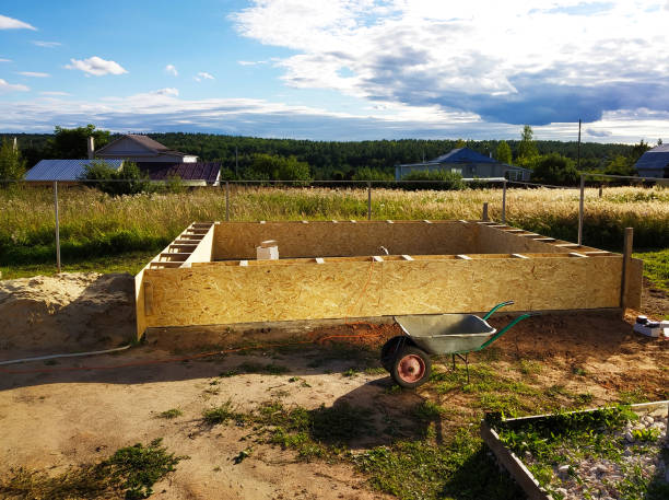 istock Wooden framework for foundation in the land on background sky 1283890095
