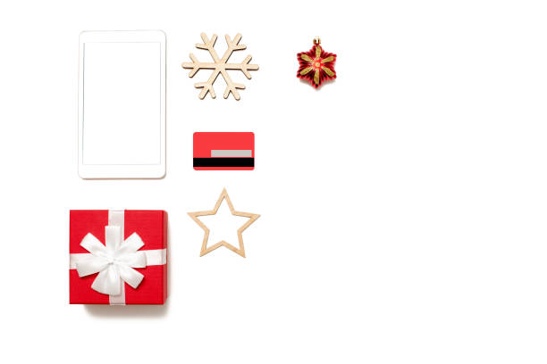 istock Digital tablet with copy space top view on white table, credit card, present box and christmas toys 1283891303