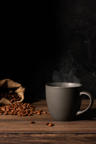 istock Cup of coffee and coffee beans on a wooden table 1283891578