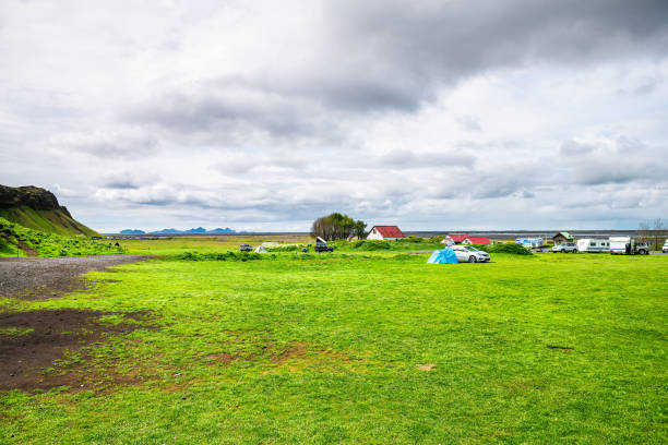 セルジャランズフォス、緑豊かな夏の風景とキャンプテントや駐車場と曇りの日に家とアイスランドの滝エリア - camping outdoors iceland red ストックフォトと画像
