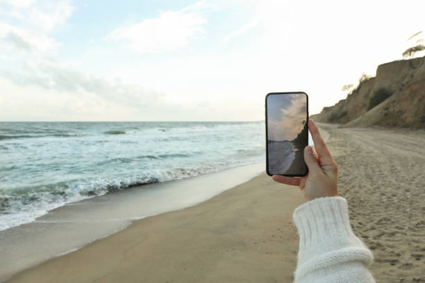 istock Female hand hold phone with making selfie on sea 1283891851