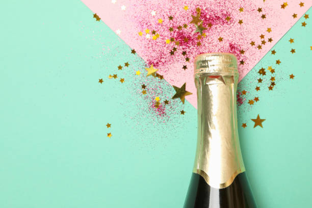 istock Bottle of champagne and glitter on mint background 1283892937