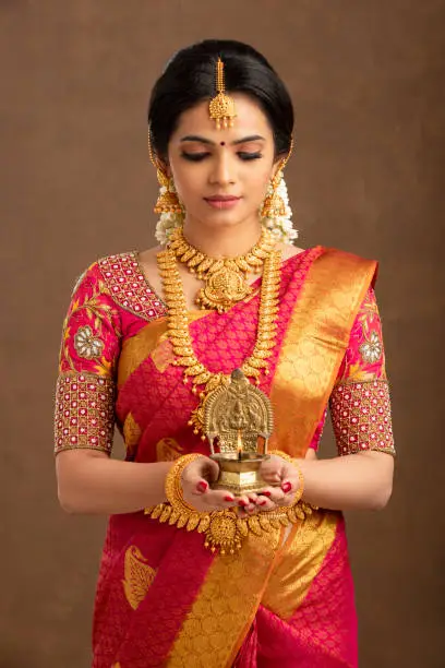 Hindu Indian young bride holding Deepa in studio shot.