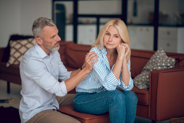 istock Man and woman sitting on the sofa and looking thoughtful 1283895429