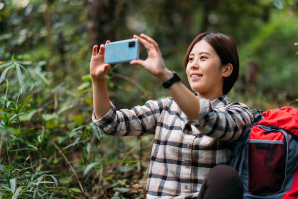 istock Young female hiker taking photos with mobile phone in nature 1283896227