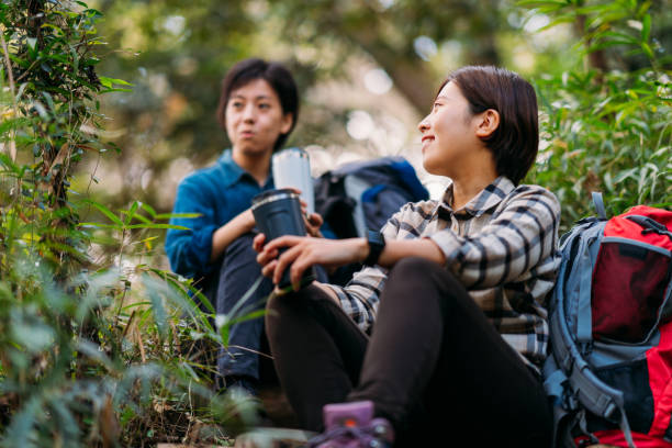 istock Two female friends taking break and talking in nature during hiking 1283896304