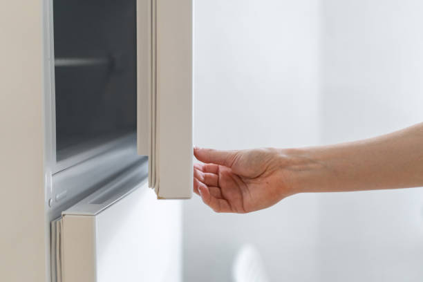 istock Woman opening door on modern electric refrigerator 1283899569