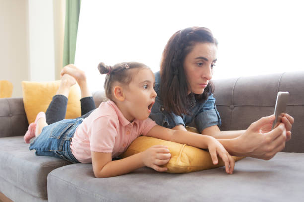 istock Mother and daughter using phone 1283901203