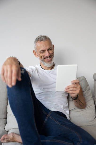 istock Smiling mature male reading information on a tablet 1283903576