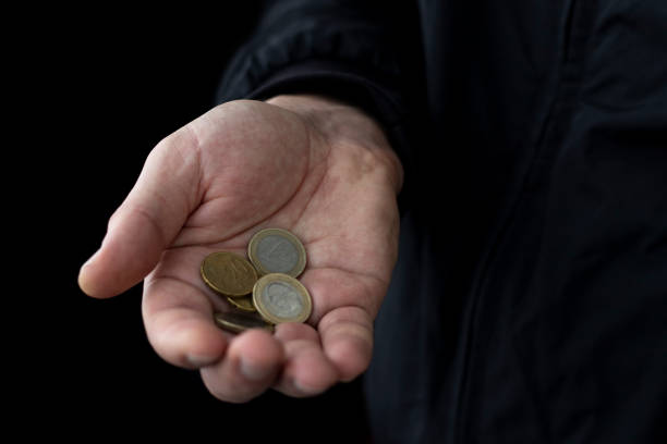 istock Euro coins in male hand on black background. 1283907443