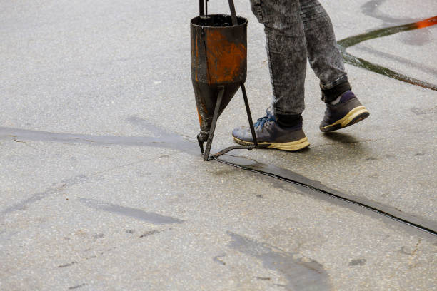 istock Workers applying blacktop sealer to asphalt a road protective coat 1283908847